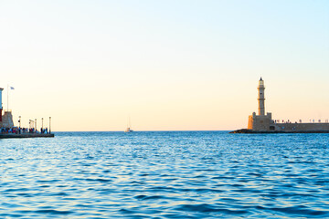 Fototapeta premium bay of Chania with sea and lighthouse at sunny summer sunset, Crete, Greece, web banner format