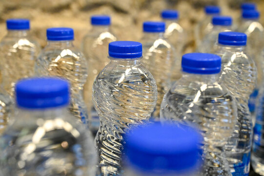 Water bottles in a water factory. Filled plastic bottles on production line. Plastic water bottles moving along an conveyor belt inside a modern water bottling facility. Water bottling. Water industry