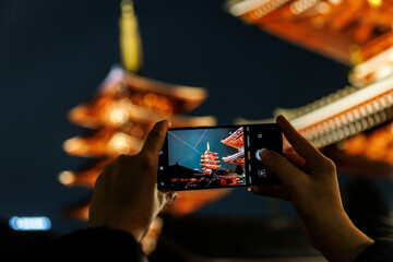 Smartphone Photographing Illuminated Japanese Pagoda at Night