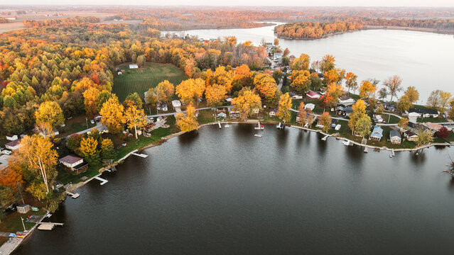 Aerial view of a lakeside neighborhood surrounded by vibrant autumn trees