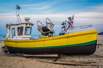 Naklejka premium Fishing boat on Baltic Sea beach in Karlikowo District in Sopot city, Poland