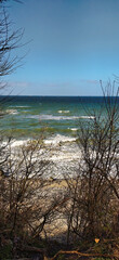 Baltic Sea with waves breaking through bushes near Kuehlungsborn in summer