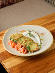 flavorful salmon pancake paired with crispy zucchini and delicately smoked salmon slices for delightful meal