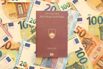 Slovenia passport lies on big amount of euro money banknotes close up. Rich life and travel in...