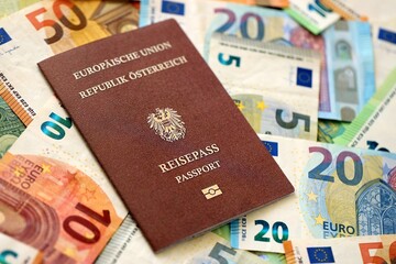 Austria passport lies on big amount of euro money banknotes close up. Rich life and travel in...