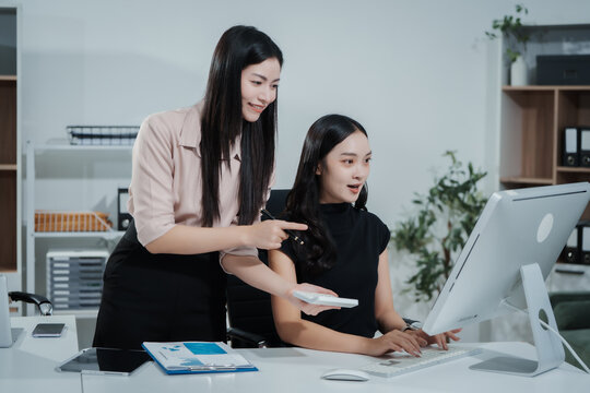 Asian businesswoman working at desk, analyzing data, reviewing reports, providing consultation, strategizing marketing, finance, and accounting tasks, focused, professional, organized, using laptop - Powered by Adobe