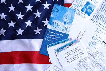Permanent resident green card in envelope with application and guide for new immigrants lies on US...