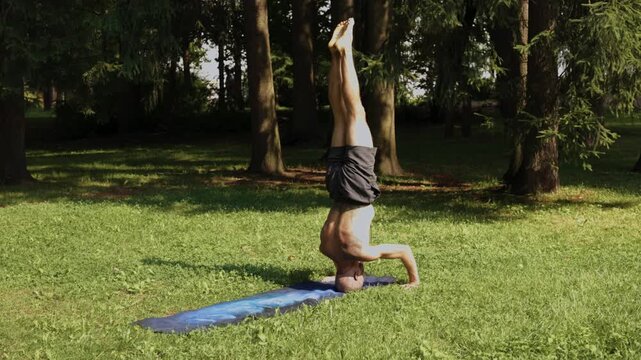 Man performing smooth mobility and roll transitions barefoot outdoors