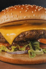 a mouthwatering close-up of a perfectly constructed burger with a sesame seed bun and melted cheese