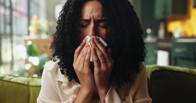 Woman, sneeze or blowing nose on couch with tissue for influenza, health problem and virus symptoms. Sick person, allergies or illness in home with toilet paper for hayfever, cold or sinus infection.