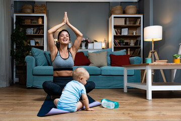 Young mother practicing yoga at home with baby nearby balancing postpartum recovery mindfulness gentle movement during evening workout joy family bonding on mat calm wellness routine for active parent