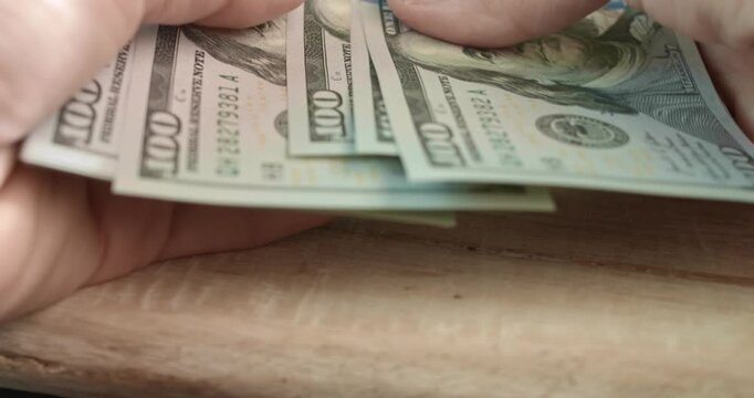 Close up view counting a stack of 100 US dollars