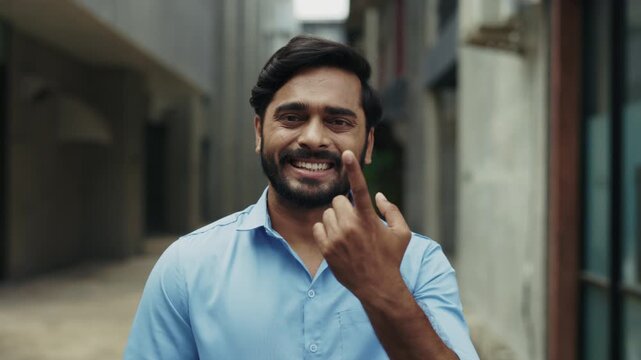 Portrait of smiling Indian businessman talks with sign language in town slow motion. Deaf male entrepreneur gestures sharing feelings in urban district. Non verbal communication