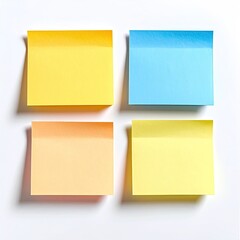 Four colorful sticky notes arranged in a square grid on a white surface.  The notes are different pastel shades of yellow, orange, and light blue.  Shadows are cast by the notes