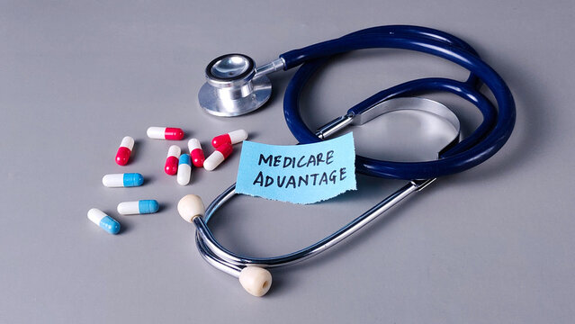 Medicare Advantage Concept with Stethoscope, Note, and Capsules on Gray Background
