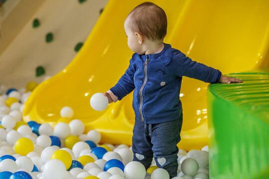 Toddler playing with ball in indoor playground pit