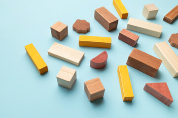 Montessori style cubes game for toddlers flat lay top view. Wooden children's construction set blocks of different shapes natural colors on blue background. Concept of learning and education