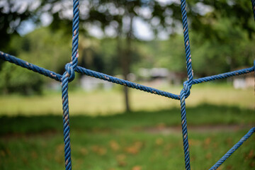 Closeup of blue ropes tied in a knot at a park playground setting