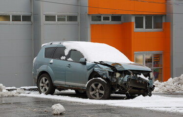 A snow-covered, broken light blue car is abandoned on the street, Podvoyskogo Street, Saint Petersburg, Russia, November 25, 2025