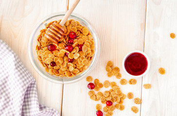 flakes in bowl with berries on wooden background top view