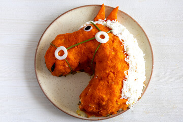 Creative funny layer salad in red horse head shape. Chinese new year or children birthday party meal. DIY
