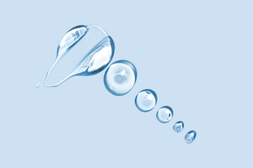 Glycerin gel texture. Transparent serum drop on blue background. Liquid gel moisturizer with bubbles macro.
