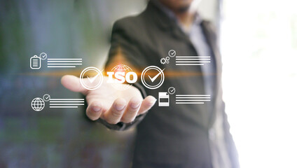 Businessman holding Quality assurance icon on digital screen with check mark icon for ISO certification and standardization. Quality assurance concept.