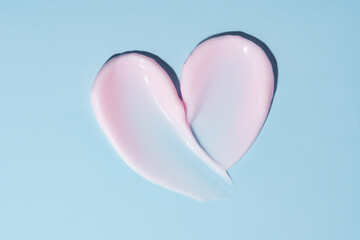 Texture of pink cream on blue background. Smear of moisturizer close up. Lotion swatch. Beauty skin care product smear smudge. SPF sunscreen cream sample on blue background