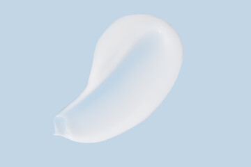 Texture of white cream on blue background. Smear of moisturizer close up. Lotion swatch. Beauty skin care product smear smudge. SPF sunscreen cream sample on blue background