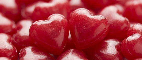 Vibrant macro shot of glossy red heart-shaped candies for Valentine’s Day.