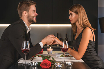Pleased happy married couple having romantic dinner in candlelight. Special event celebration, Valentine`s day and anniversary, birthday party for two. Dating concept