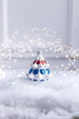 Obraz premium snowy christmas tree scene with decorative ceramic ornament and soft bokeh lights