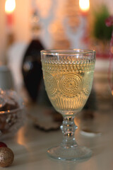Cookie jar, tea, wine, nuts, books, lit candles and Christmas decorations on the table. Cozy Christmas hygge at home. Selective focus.