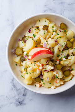 Traditional German potato salad with pickles, onions and apple.