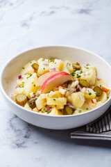 Traditional German potato salad with pickles, onions and apple.