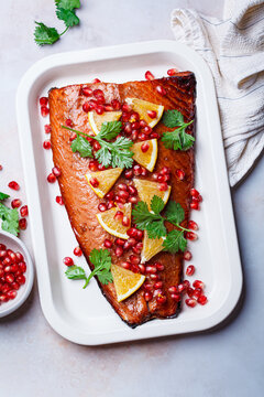Christmas salmon in pomegranate juice with orange and pomegranate seeds.