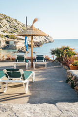 parasols et transats sur une plage de Majorque. Vacances aux Bal&eacute;ares. Chaise longue face &agrave; la mer m&eacute;diterran&eacute;e.