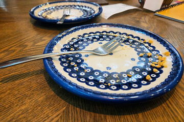 Empty Plates with Forks on Wooden Table Dining Experience and Culinary Art Concept