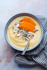 Persimmon smoothie bowl with chia seeds and nuts.