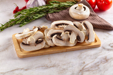 Raw champignon slices on the board