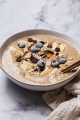 Chocolate smoothie bowl with banana, blueberries and nuts.