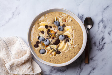 Chocolate smoothie bowl with banana, blueberries and nuts.