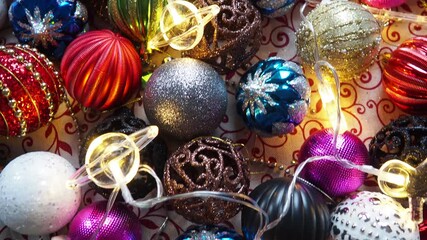 Bright and shiny ornaments are arranged on a surface, showcasing various colors and textures, setting a joyful tone for holiday celebrations and decorating activities