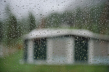 Looking outside the camper at a tent at the camping while it is raining