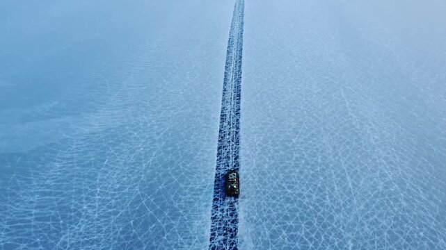 Aerial top down Hivus hovercrafts glide across endless winter ice of frozen Lake Baikal. Natural landscape, vast expanse UNESCO heritage site, amazing off-road adventure tourism Russia