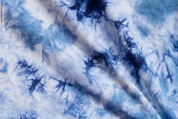 Fototapeta premium Close-up batik shirt with indigo blue dye on white fabric cotton background on top-view