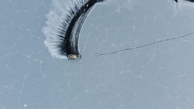 Aerial top down Hivus hovercrafts glide across endless winter ice of frozen Lake Baikal. Natural landscape, vast expanse UNESCO heritage site, amazing off-road adventure tourism Russia