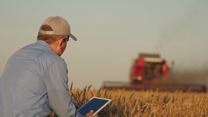 farmer working in wheat field, combine harvester ploughing in wheat field, agriculture tablet, innovations in agriculture, sustainable farming practices, maximizing harvest efficiency, connecting