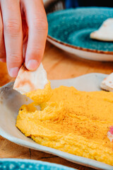 dipping naan into curry hummus at a restaurant