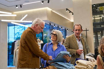 Senior couple shopping for new clothes in store